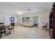 Bright living room with tile flooring and a large window that provides natural light and a cozy seating area at 5159 N Monte Cristo Way, Las Vegas, NV 89149