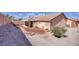 Wide backyard with rock garden, covered patio, and minimal landscaping at 5441 Rose Hills St, Las Vegas, NV 89149