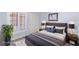Staged bedroom features wood-look floors, large window with blinds, neutral paint, and modern furniture at 5441 Rose Hills St, Las Vegas, NV 89149