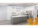 Bright kitchen features white cabinets, stainless steel appliances, subway tile backsplash, and a gray island with a marble countertop at 5441 Rose Hills St, Las Vegas, NV 89149