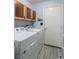 Bright laundry area with white appliances and natural-look wood-style flooring at 5441 Rose Hills St, Las Vegas, NV 89149