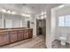 Bright bathroom with a double vanity, granite counters, and a walk-in shower with dark stone at 5661 Brimstone Hill Ave, Las Vegas, NV 89141