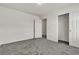 View of a bedroom with gray carpet, white walls, closet, and entry door at 5661 Brimstone Hill Ave, Las Vegas, NV 89141
