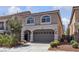 Two-story home featuring an attached two-car garage, small garden and gated entry at 5661 Brimstone Hill Ave, Las Vegas, NV 89141
