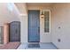 Close-up of a gray front door, sidelight window and landscaped entry with wrought iron at 5661 Brimstone Hill Ave, Las Vegas, NV 89141