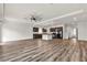 Large open-concept living room with modern flooring, ceiling fan and kitchen view at 5661 Brimstone Hill Ave, Las Vegas, NV 89141