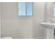 Powder room with a pedestal sink, round mirror, window and white walls at 5661 Brimstone Hill Ave, Las Vegas, NV 89141