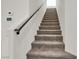 Carpeted staircase with a dark wood railing, leading to the upper level of the home at 5661 Brimstone Hill Ave, Las Vegas, NV 89141