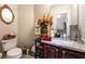 Half bath with granite countertop, marble floors and decorative mirror at 5854 Willow Trace Ave, Las Vegas, NV 89139