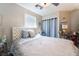 This bedroom features a ceiling fan, mirror nightstands, and a luxurious bed with a silver and white decor at 5854 Willow Trace Ave, Las Vegas, NV 89139