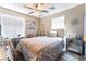 This bedroom features a ceiling fan, mirror nightstands, and a luxurious bed with a silver and white decor at 5854 Willow Trace Ave, Las Vegas, NV 89139