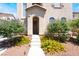 Close up of front door and desert landscaping featuring colorful flowers and small shrubs at 5854 Willow Trace Ave, Las Vegas, NV 89139