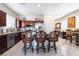 Bright kitchen with dark cabinets, stainless steel appliances, granite counters and breakfast bar with three chairs at 5854 Willow Trace Ave, Las Vegas, NV 89139