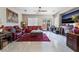 Elegant living room with plush red leather seating, tile floors, ceiling fan and fireplace at 5854 Willow Trace Ave, Las Vegas, NV 89139