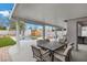 Inviting covered patio area with a dining table and grill, overlooking a pool and backyard at 5937 Round Castle St, Las Vegas, NV 89130