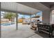 Covered patio with backyard view of pool, fire pit, grill, and well-maintained landscaping at 5937 Round Castle St, Las Vegas, NV 89130