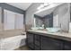Stylish bathroom featuring dual glass bowl sinks, a tub, and a shower with gray tile at 5937 Round Castle St, Las Vegas, NV 89130