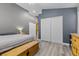 Bright bedroom with gray walls, white closet doors, wood floors, and natural wood furniture at 5937 Round Castle St, Las Vegas, NV 89130