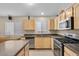 Well-lit kitchen with light wood cabinets, stainless steel appliances, and dark countertops at 5937 Round Castle St, Las Vegas, NV 89130