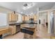 The kitchen features wooden cabinets, stainless steel appliances, a kitchen island, and tile floors at 5937 Round Castle St, Las Vegas, NV 89130