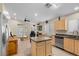 This kitchen is between the living room and the refrigerator with wooden cabinets and tile floors at 5937 Round Castle St, Las Vegas, NV 89130