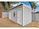 This image showcases a gray outbuilding with two doors and a window in the backyard at 5937 Round Castle St, Las Vegas, NV 89130