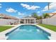 A clear in-ground swimming pool is surrounded by green turf and a covered patio at 5937 Round Castle St, Las Vegas, NV 89130