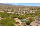 Community aerial showcasing homes with solar panels and green spaces against a mountain backdrop at 6049 Paddleboat St, North Las Vegas, NV 89031