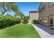 Landscaped backyard with artificial turf, mature landscaping, and a paved patio area at 6049 Paddleboat St, North Las Vegas, NV 89031