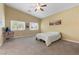 Neutral bedroom featuring carpet, bright windows, ceiling fan and light yellow walls at 6049 Paddleboat St, North Las Vegas, NV 89031
