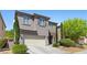 Charming two-story home featuring a two-car garage, landscaped front yard, and modern exterior design at 6049 Paddleboat St, North Las Vegas, NV 89031