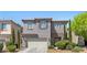 Inviting two-story home with a two-car garage, neat landscaping, and a welcoming entrance at 6049 Paddleboat St, North Las Vegas, NV 89031