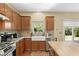 The Kitchen showcases stone counters, stainless appliances, a farmhouse sink and backyard views at 6049 Paddleboat St, North Las Vegas, NV 89031