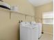 Laundry room with shelving above the washer and dryer, providing ample storage space and functionality at 6049 Paddleboat St, North Las Vegas, NV 89031