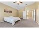 A bright primary bedroom boasts a ceiling fan, carpet, and neutral walls at 6049 Paddleboat St, North Las Vegas, NV 89031