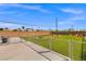 Wide backyard with green grass, and a chainlink fence at 6210 Blood Lily Ave, Las Vegas, NV 89122