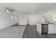 Spacious living room with hardwood floors and carpet, featuring a modern ceiling fan and bright lighting at 6233 Blood Lily Ave, Las Vegas, NV 89122