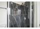 Close-up of remodeled shower with sleek marble-style tile and modern fixtures at 6244 Parsifal Pl, Las Vegas, NV 89107