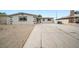 The front exterior features a spacious driveway with gravel landscaping and a simple design at 6244 Parsifal Pl, Las Vegas, NV 89107