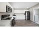 Modern kitchen features stainless steel appliances, white cabinets, quartz countertops, and hardwood floors at 6244 Parsifal Pl, Las Vegas, NV 89107