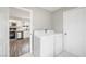 Laundry room with white washer and dryer units seen from doorway to kitchen at 6244 Parsifal Pl, Las Vegas, NV 89107