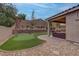 Beautiful backyard with putting green, stone patio and covered seating area with mountain views at 6985 Hopi Summit Ct, Las Vegas, NV 89149