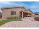 Covered patio and spacious backyard featuring artificial grass and stone patio with outdoor seating at 6985 Hopi Summit Ct, Las Vegas, NV 89149