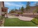 Large backyard featuring artificial grass, patio, built-in seating area, mature trees and privacy wall at 6985 Hopi Summit Ct, Las Vegas, NV 89149