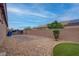 Spacious backyard with low maintenance landscaping, a stone patio, and privacy fencing at 6985 Hopi Summit Ct, Las Vegas, NV 89149