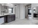 A bathroom with dual sinks, dark cabinets, light gray walls, and modern tile floor at 6985 Hopi Summit Ct, Las Vegas, NV 89149