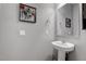 Cozy powder room featuring pedestal sink, framed mirror and decorative wall art at 6985 Hopi Summit Ct, Las Vegas, NV 89149