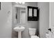 Cozy powder room featuring pedestal sink, framed mirror and a black cabinet with storage baskets at 6985 Hopi Summit Ct, Las Vegas, NV 89149