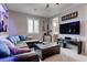 A stylish room features L-shaped couch, guitars, and wall-mounted TV at 6985 Hopi Summit Ct, Las Vegas, NV 89149
