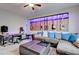 A music-themed room featuring an L-shaped couch, guitars, and a wood panel wall at 6985 Hopi Summit Ct, Las Vegas, NV 89149